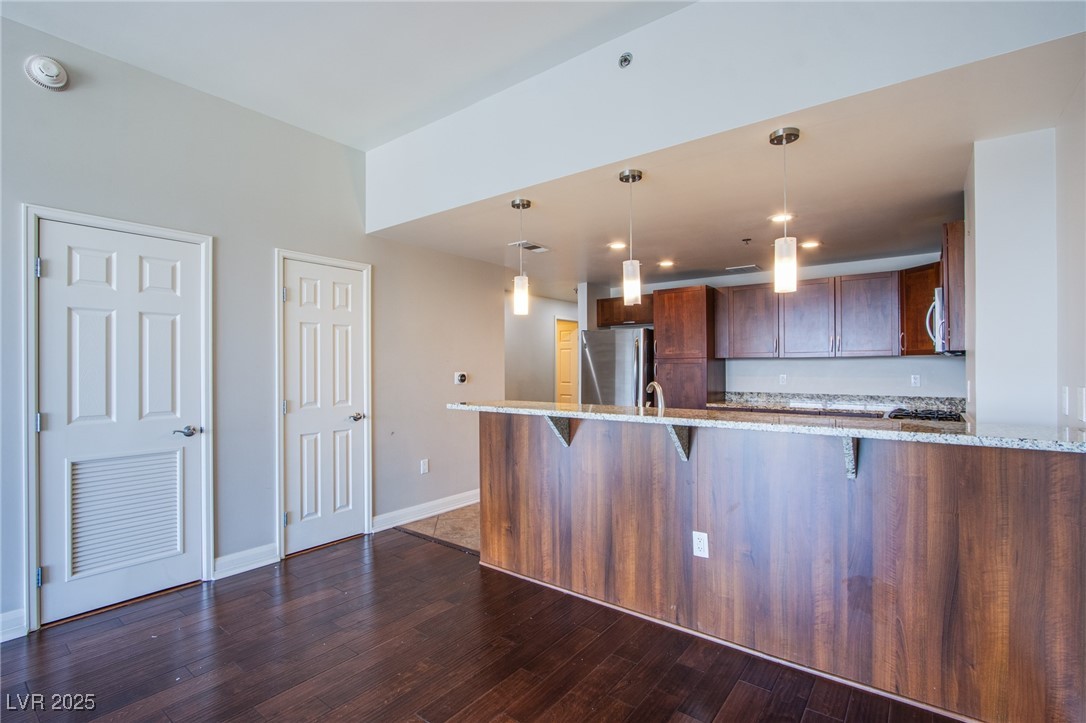 150 South Las Vegas Boulevard, Unit 1212 Las Vegas, NV 89101 - Photo 5 of 45 Kitchen featuring appliances with stainless steel finishes, light stone counters, a breakfast bar area, and recessed lighting