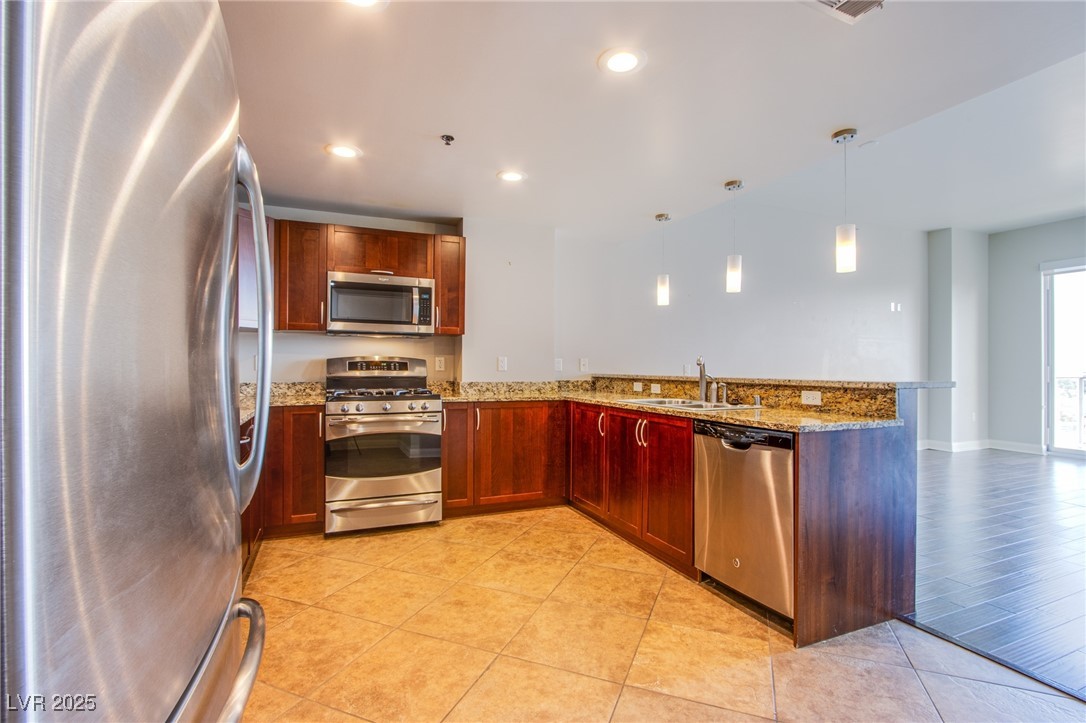 150 South Las Vegas Boulevard, Unit 1212 Las Vegas, NV 89101 - Photo 6 of 45 Kitchen featuring stainless steel appliances, a peninsula, a sink, light stone counters, and recessed lighting