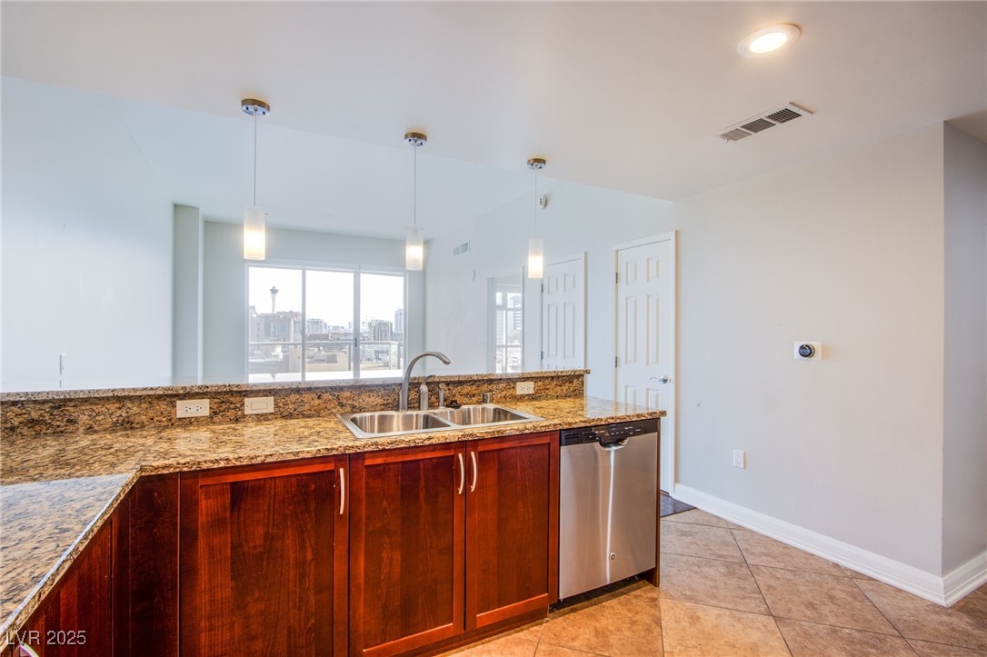150 South Las Vegas Boulevard, Unit 1212 Las Vegas, NV 89101 - Photo 7 of 45 Kitchen featuring stainless steel dishwasher, a sink, light stone countertops, pendant lighting, and light tile patterned flooring