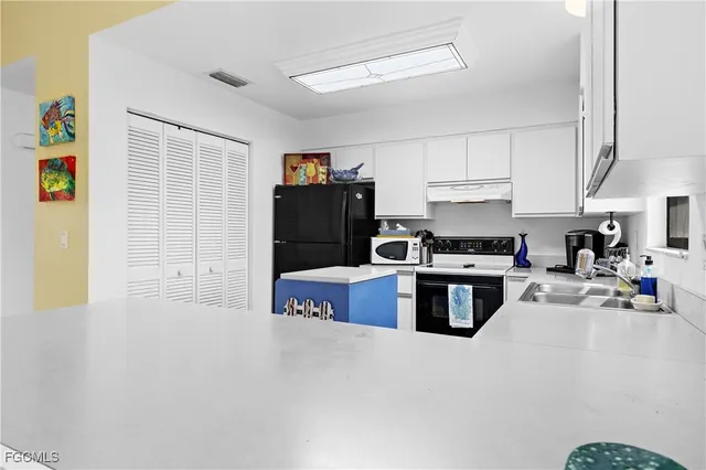 a kitchen with stainless steel appliances granite countertop a refrigerator a stove a sink and a refrigerator