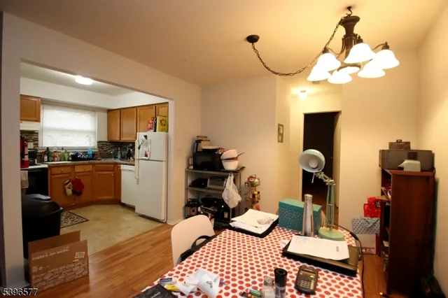 a kitchen view of a refrigerator dining table and chairs