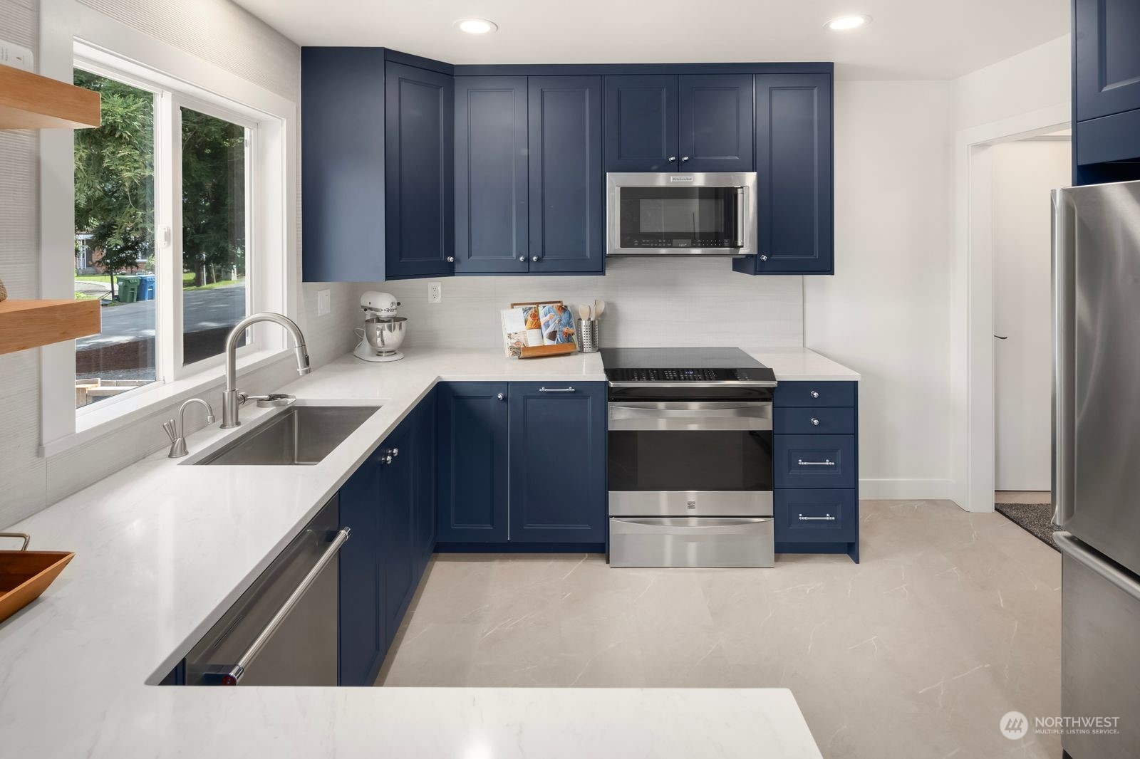 1417 North 40th Street Renton, WA 98056 - Photo 4 of 33 a kitchen with stainless steel appliances a stove a sink a microwave a refrigerator and cabinets