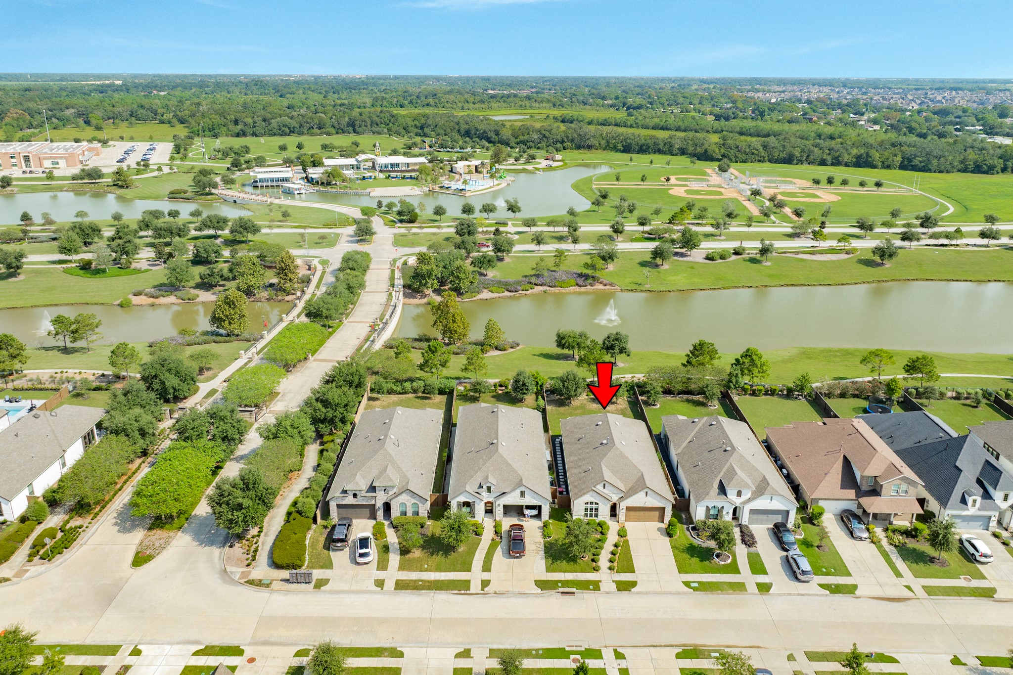 4015 Shackleton Court Iowa Colony, TX 77583 - Photo 36 of 50 Aerial view showing the neighborhood layout, gated entrance, and lake with a walking path, featuring the nearby elementary school in the background.