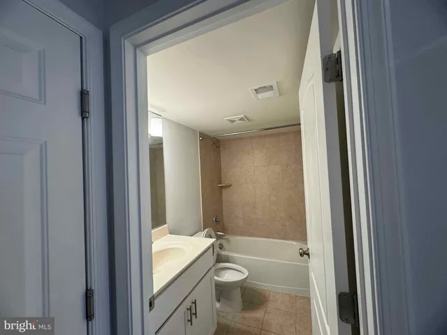 a view of a building and car parked on the side of road