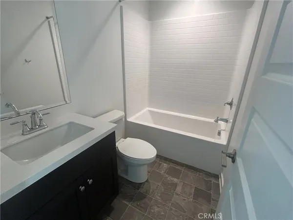 a bathroom with a granite countertop toilet a sink and a bathtub