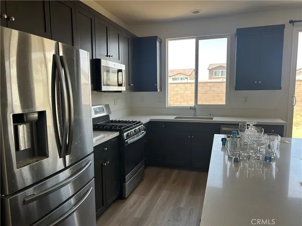 a kitchen with granite countertop a refrigerator stove and sink