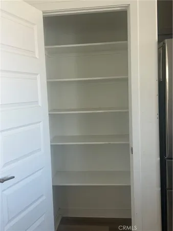 a view of walk in closet with empty racks