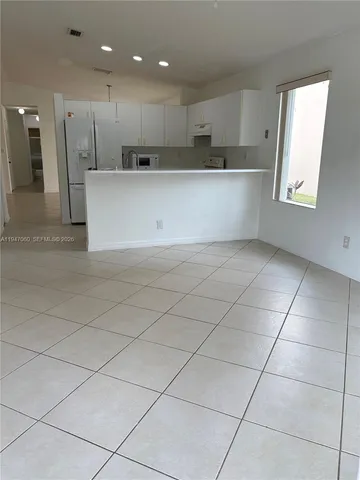 a large kitchen with a large counter top and stainless steel appliances