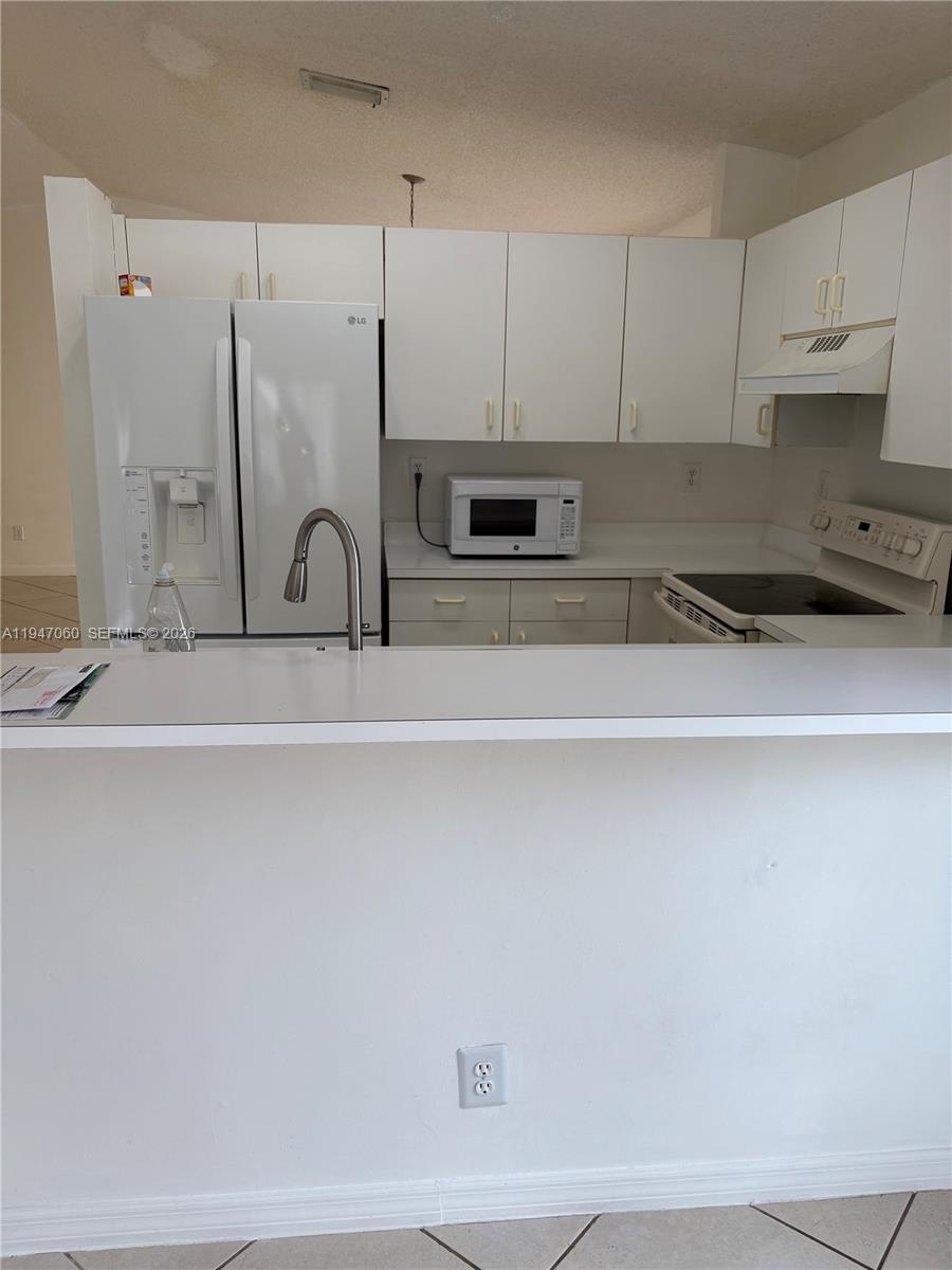 17365 Southwest 142nd Court Miami, FL 33177 - Photo 6 of 18 a kitchen with stainless steel appliances a sink a stove and white cabinets