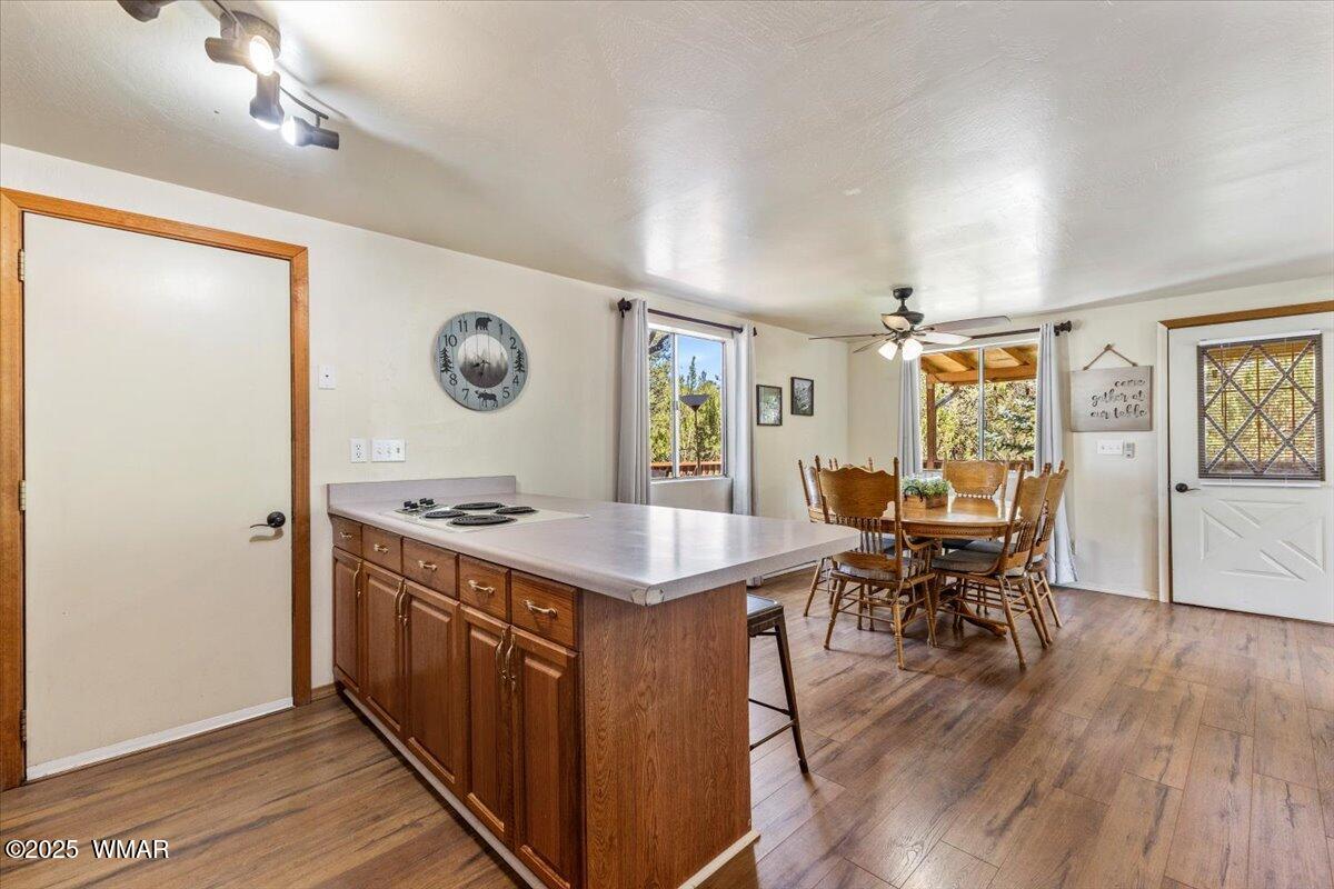 2001 Broken Arrow Road Overgaard, AZ 85933 - Photo 10 of 38 a kitchen with stainless steel appliances granite countertop a stove top oven a dining table and chairs with wooden floor