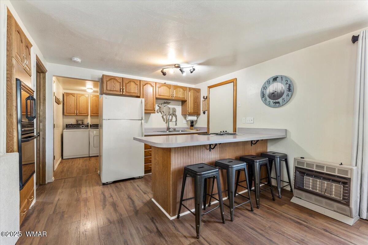 2001 Broken Arrow Road Overgaard, AZ 85933 - Photo 11 of 38 a kitchen with granite countertop a refrigerator a stove and a wooden floor