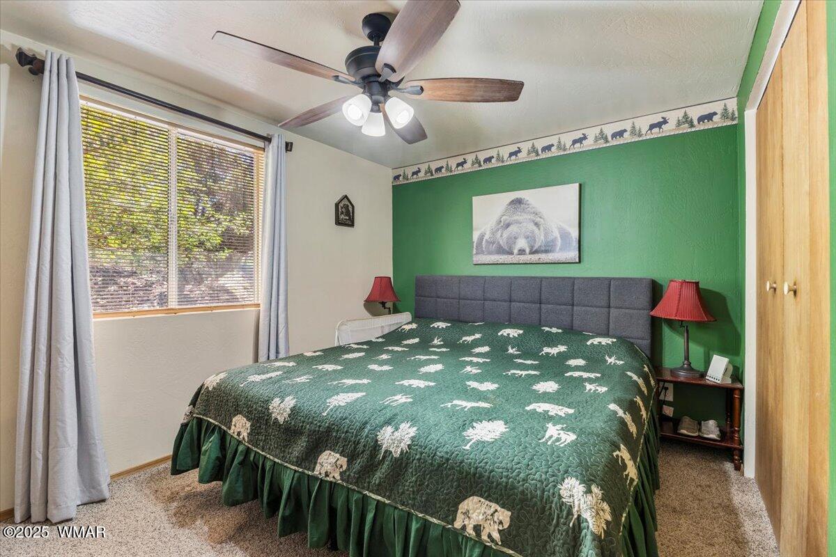 2001 Broken Arrow Road Overgaard, AZ 85933 - Photo 13 of 38 a bedroom with a bed and a chandelier
