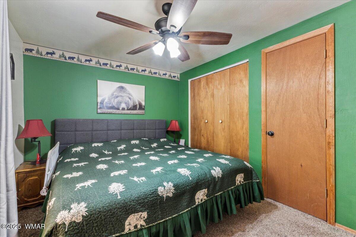 2001 Broken Arrow Road Overgaard, AZ 85933 - Photo 14 of 38 a bedroom with a bed and a chandelier