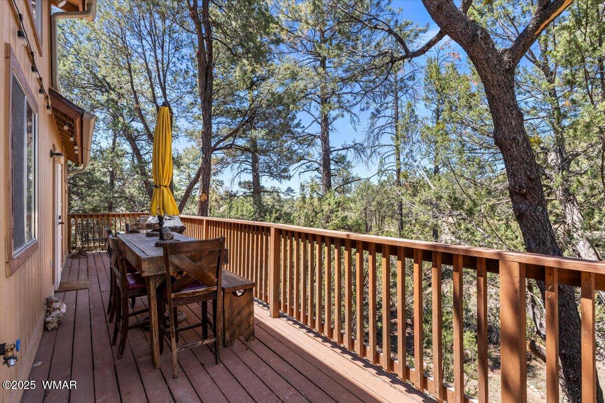 2001 Broken Arrow Road Overgaard, AZ 85933 - Photo 29 of 38 a view of a deck with table and chairs and wooden floor