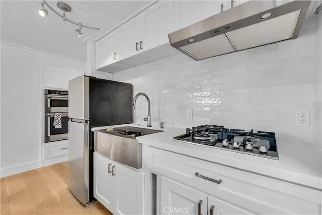 a kitchen with a refrigerator and white cabinets