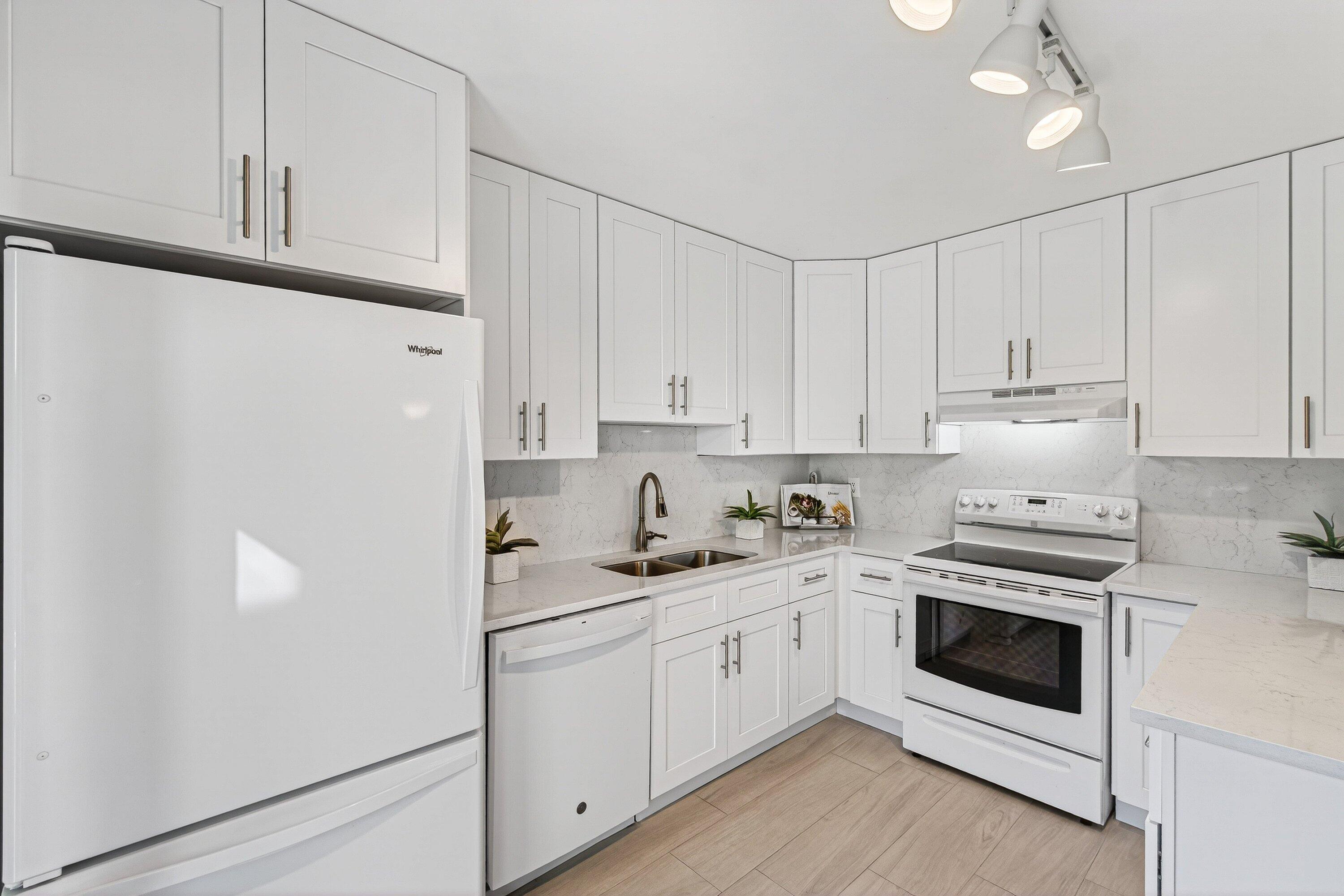 865 Northwest 29th Avenue, Unit D Delray Beach, FL 33445 - Photo 14 of 70 a kitchen with white cabinets and white appliances