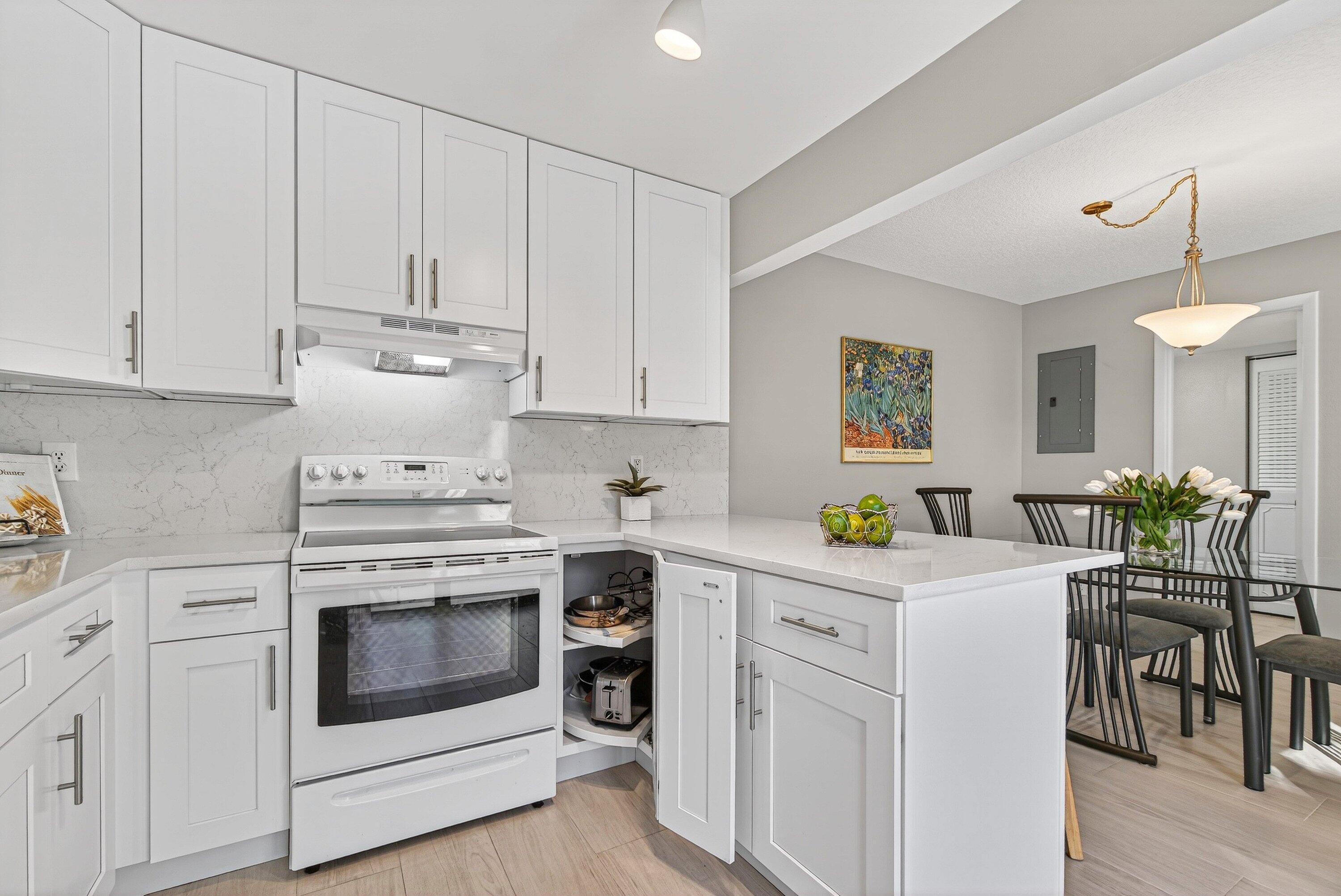 865 Northwest 29th Avenue, Unit D Delray Beach, FL 33445 - Photo 15 of 70 a kitchen with white cabinets and white appliances