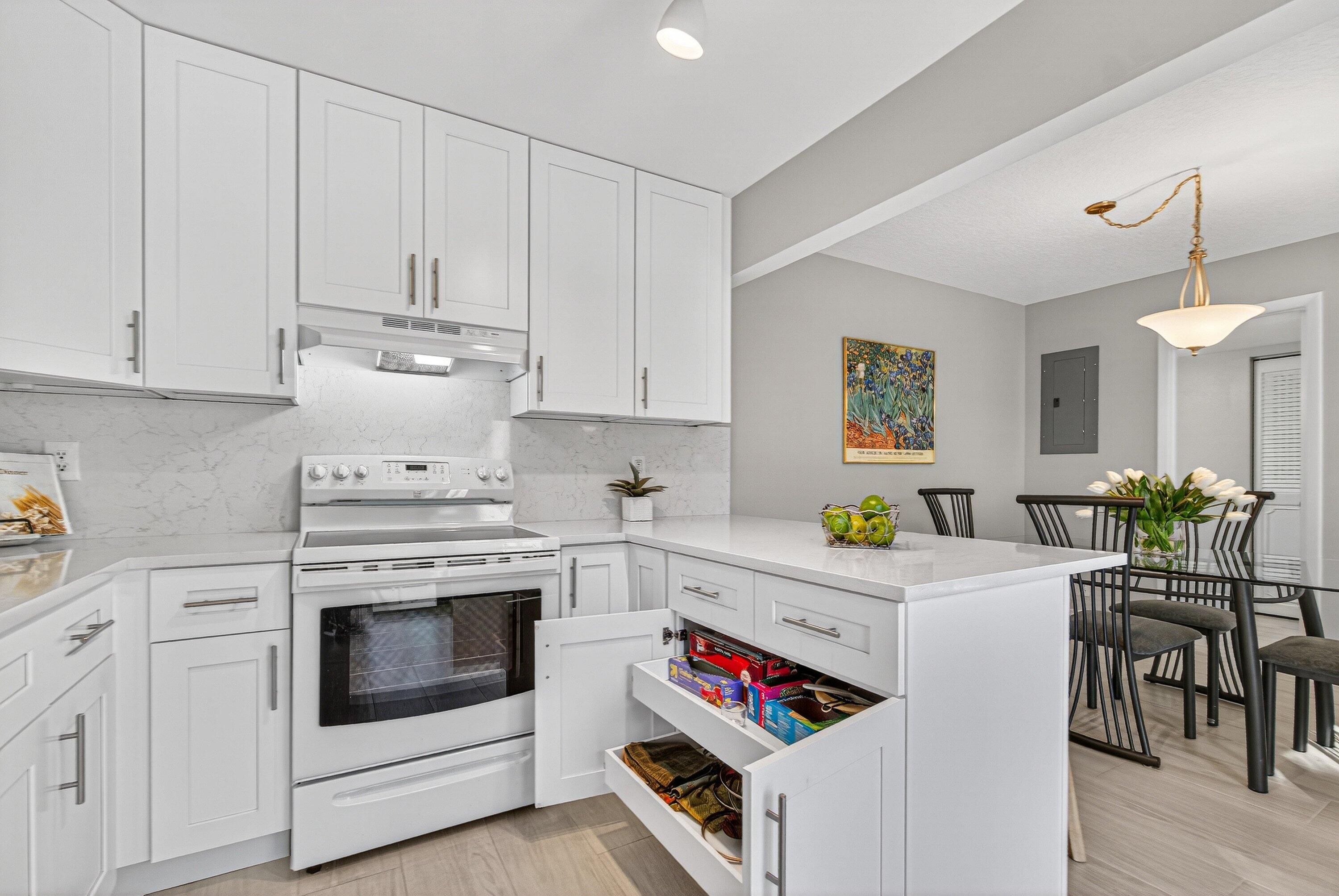 865 Northwest 29th Avenue, Unit D Delray Beach, FL 33445 - Photo 16 of 70 a kitchen with white cabinets and white appliances