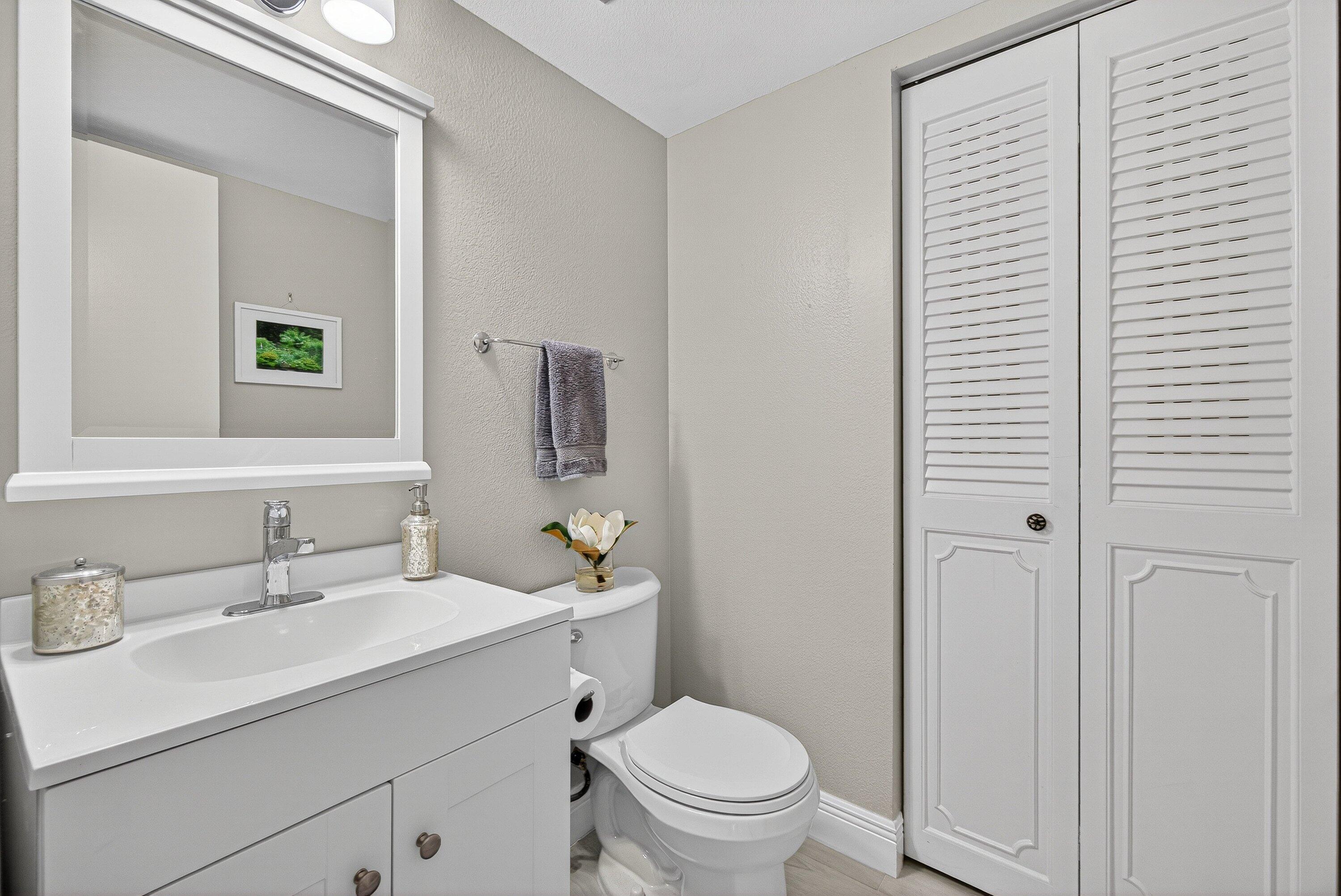 865 Northwest 29th Avenue, Unit D Delray Beach, FL 33445 - Photo 19 of 70 a bathroom with a toilet a sink a vanity and mirror