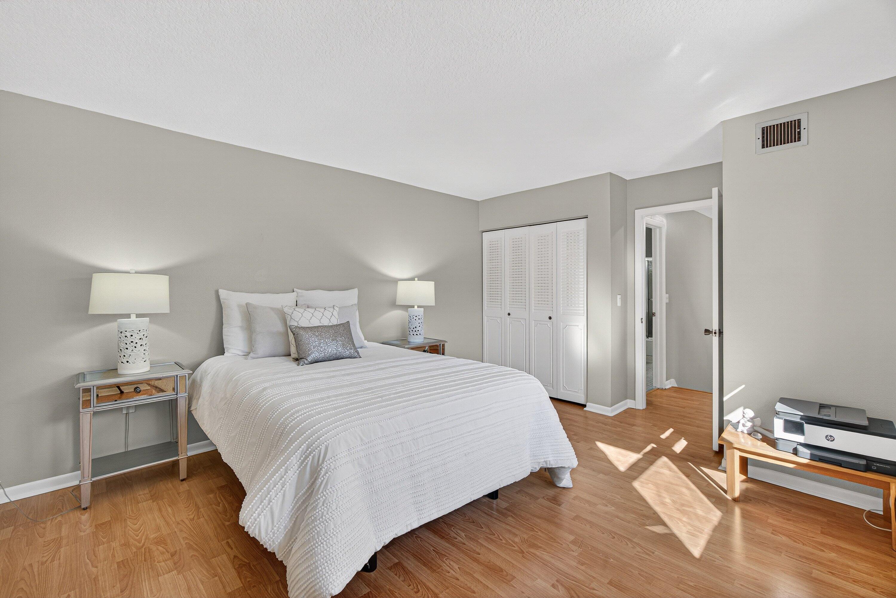 865 Northwest 29th Avenue, Unit D Delray Beach, FL 33445 - Photo 27 of 70 a bedroom with a bed and a table with wooden floor