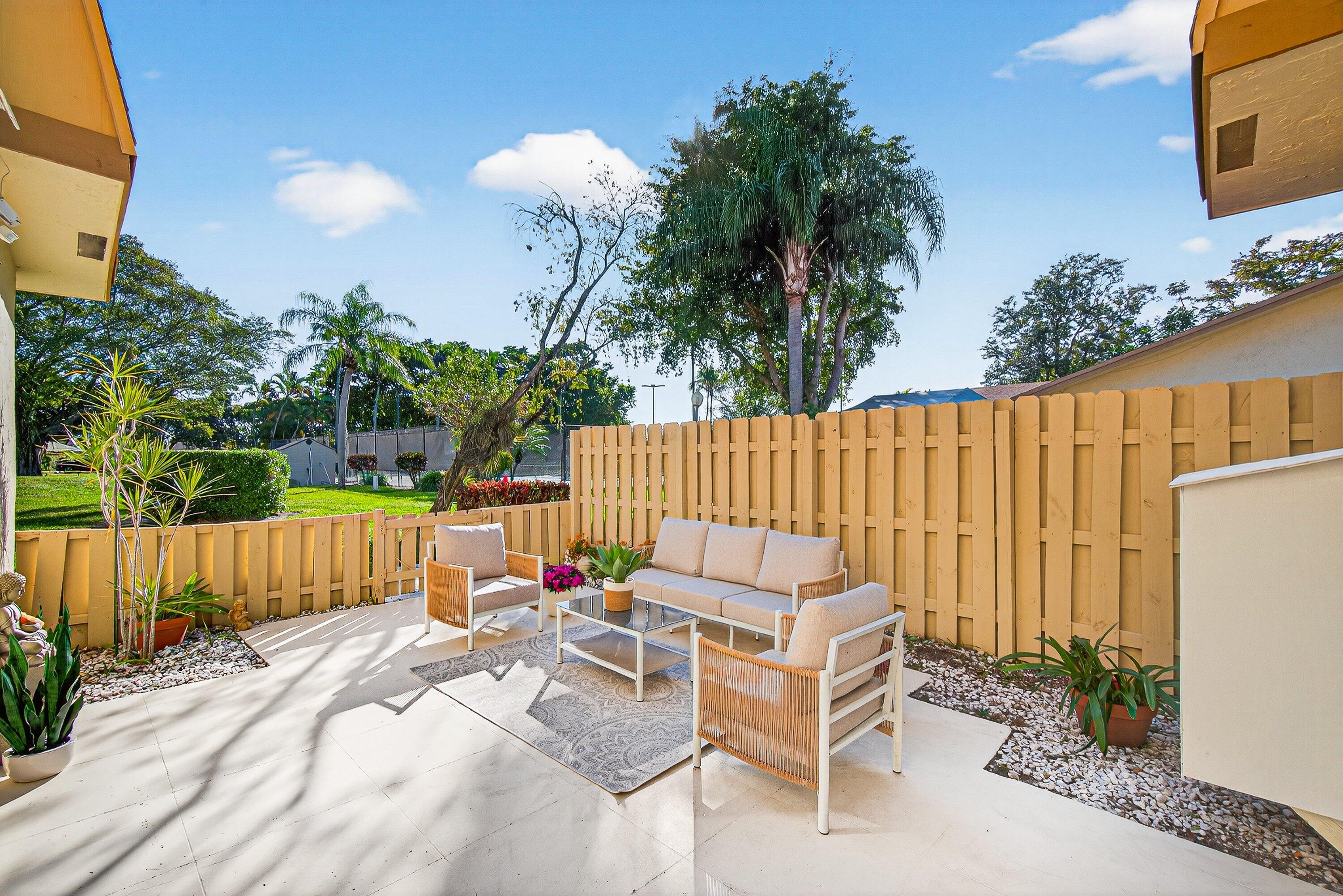 865 Northwest 29th Avenue, Unit D Delray Beach, FL 33445 - Photo 31 of 70 a view of a chairs and tables in the back yard of the house