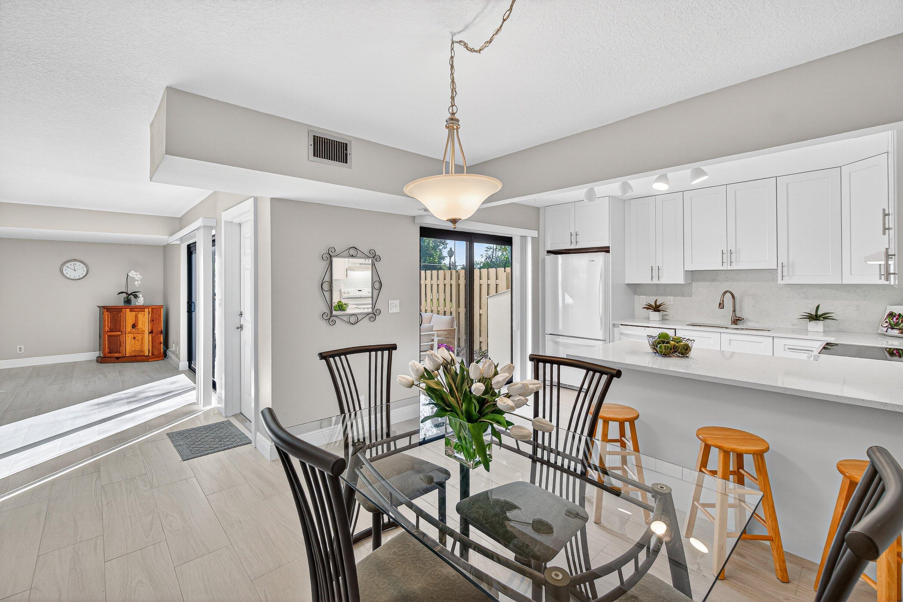 865 Northwest 29th Avenue, Unit D Delray Beach, FL 33445 - Photo 10 of 70 a view of a dining room with furniture window and wooden floor