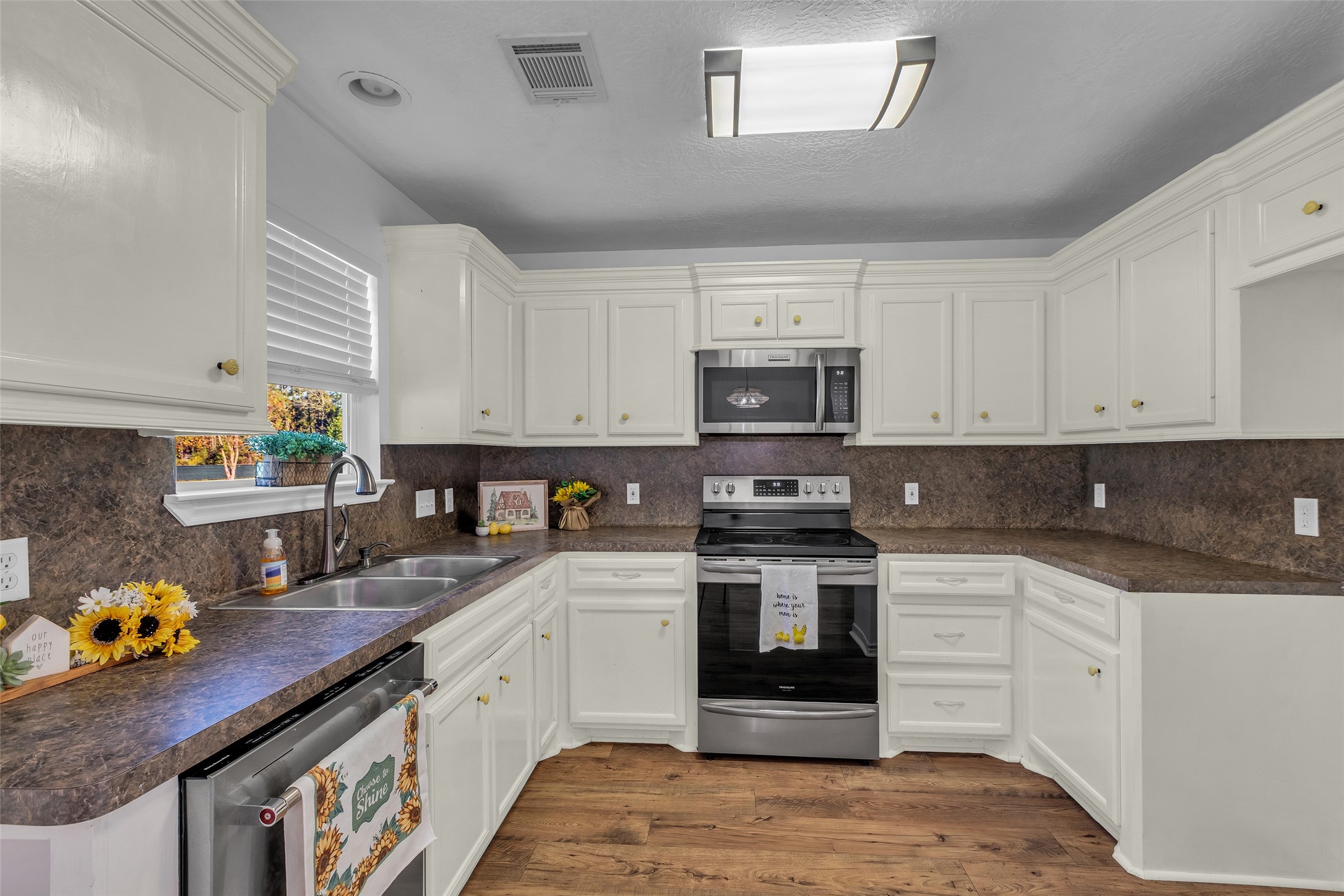3862 Highline Oaks West Conroe, TX 77306 - Photo 11 of 23 a kitchen with kitchen island granite countertop a sink a stove cabinets and wooden floor