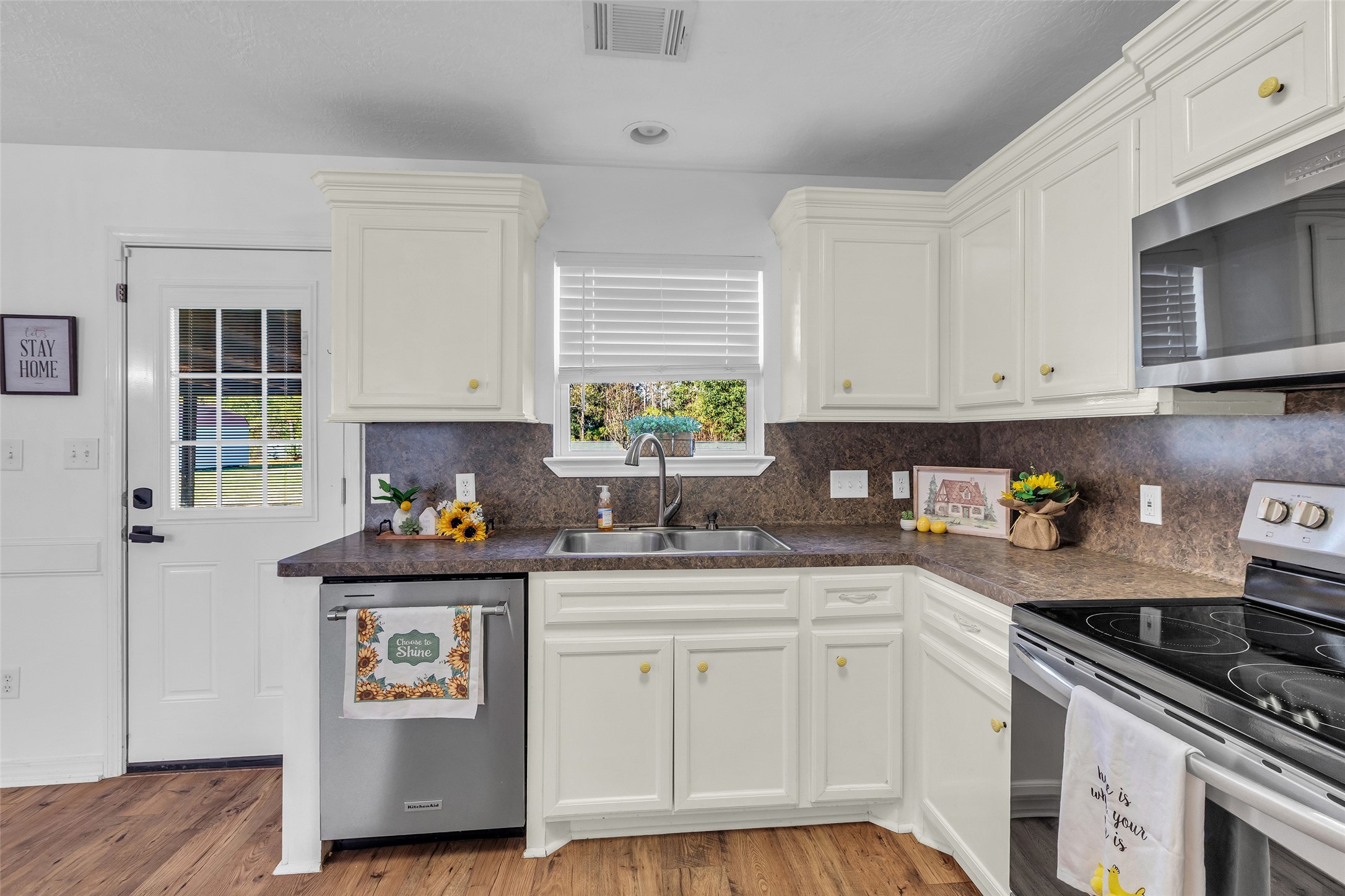 3862 Highline Oaks West Conroe, TX 77306 - Photo 12 of 23 a kitchen with stainless steel appliances white cabinets a stove a sink and a window