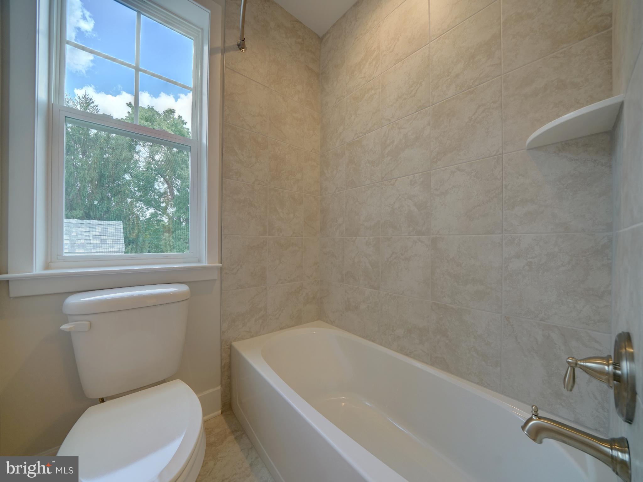9420 Fairview Avenue Laurel, MD 20723 - Photo 39 of 70 a white toilet and a bath tub sitting next to a window