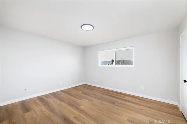 a view of a room with wooden floor and window