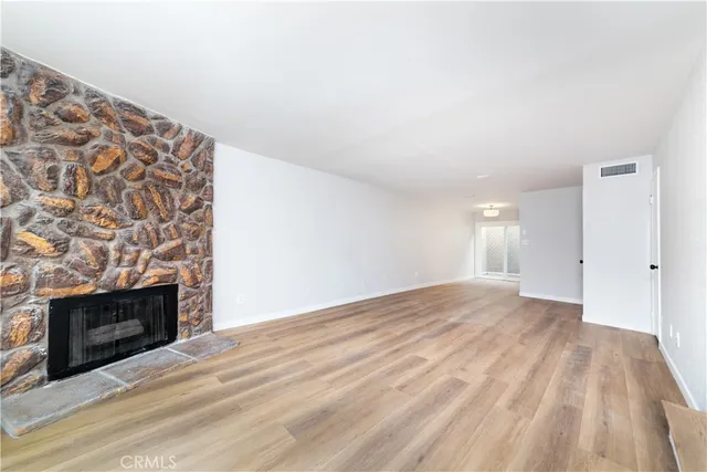 a view of empty room with wooden floor and fireplace