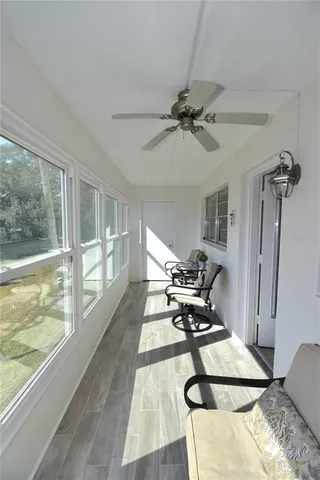 a living room with furniture a rug potted plant and a large window
