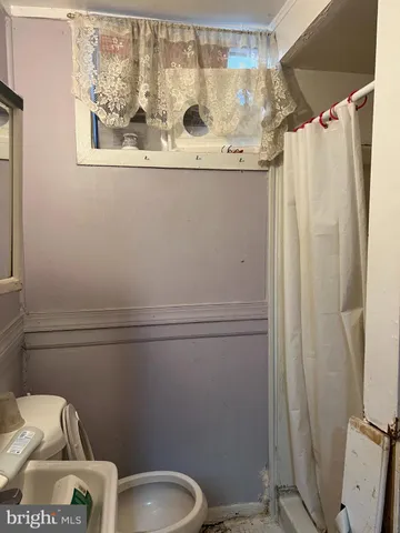 a bathroom with a granite countertop sink toilet and a mirror