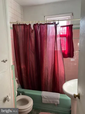 a bathroom with a toilet and a shower curtain
