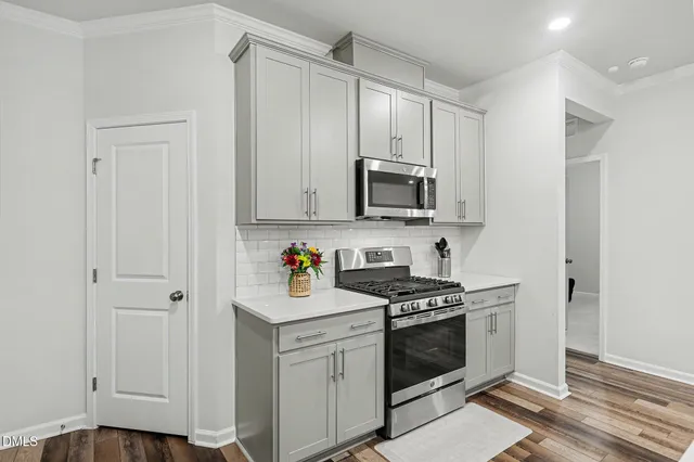 a kitchen with stainless steel appliances white cabinets and a stove top oven