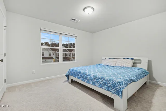 a bedroom with a bed and a painting on the wall
