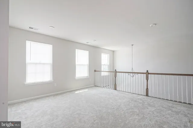 a view of empty room with window and chandelier fan