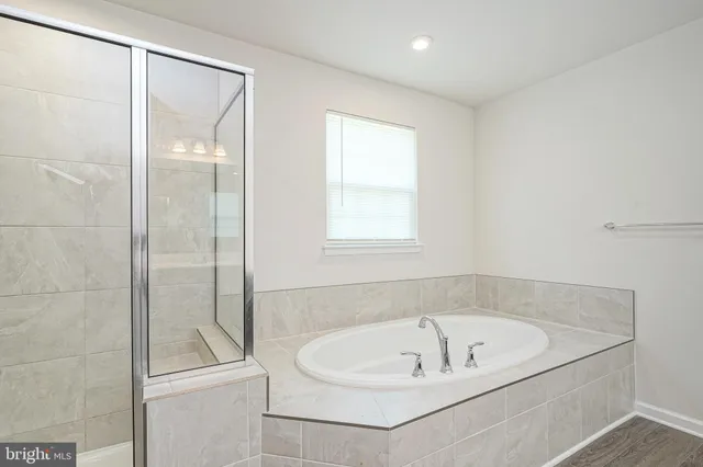 a spacious bathroom with a granite countertop sink a toilet a mirror and shower