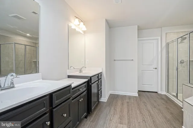 a bathroom with a tub a sink and wooden floor