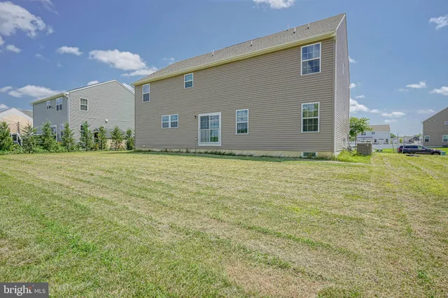 a view of a house with a big yard and potted plants