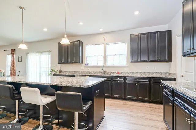 a kitchen with granite countertop wooden cabinets and black appliances