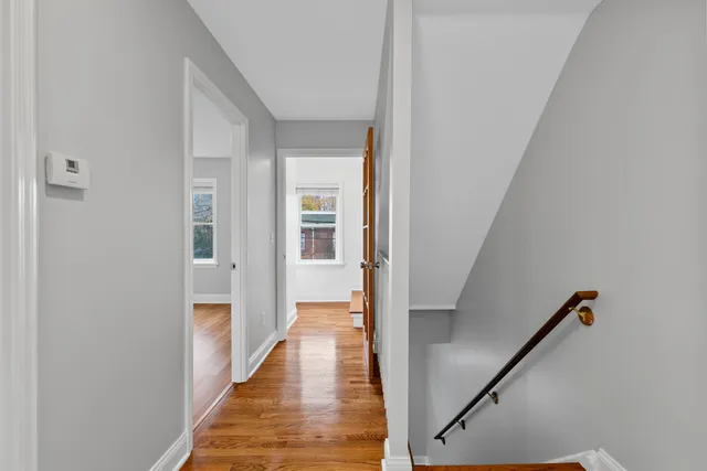 a view of a hallway with wooden floor and staircase