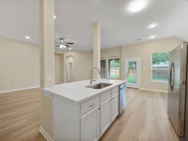 a spacious bathroom with a granite countertop sink a mirror and with shower