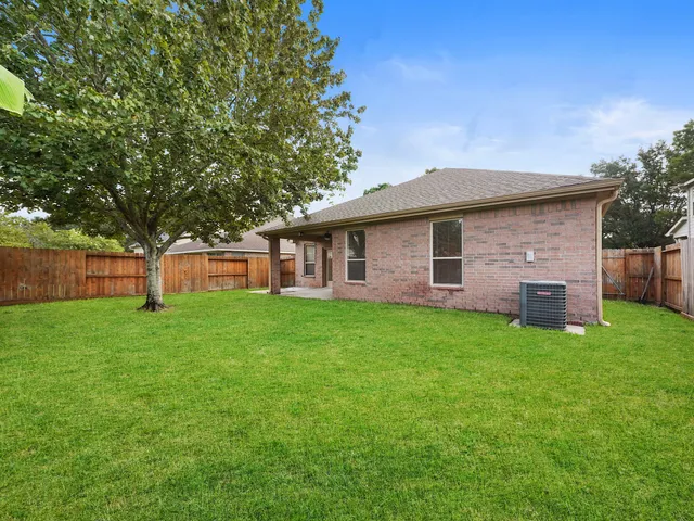 a view of an empty room with a window and a ceiling fan