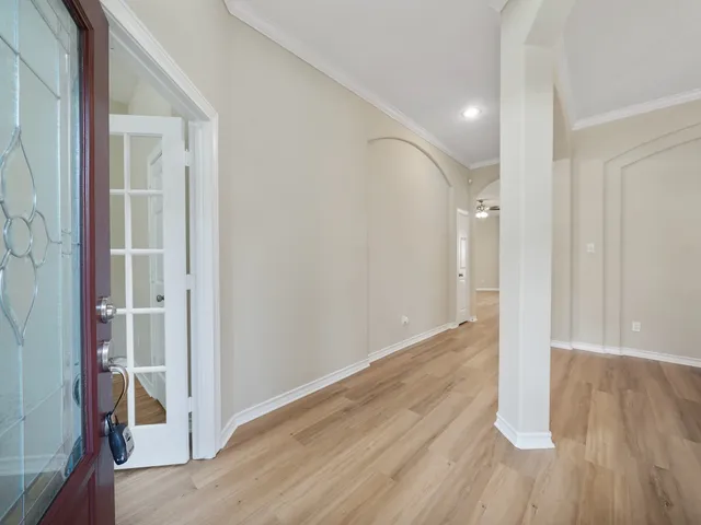 wooden floor in an empty room with a hallway
