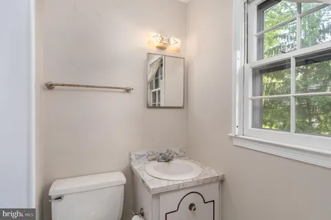 a bathroom with a toilet a sink and a window