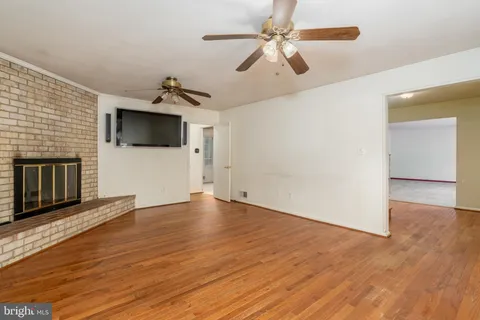a view of a livingroom with wooden floor and a ceiling fan