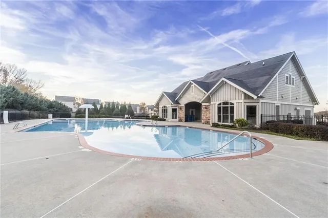 a view of a house with pool and a yard
