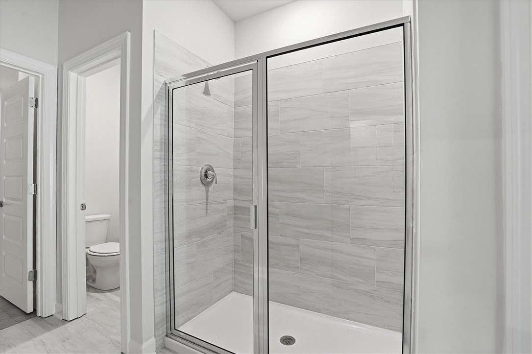 973 Penfold Pointe Point Blythewood, SC 29016 - Photo 20 of 39 This clean bathroom showcases a sleek, tiled shower with a clear glass enclosure.