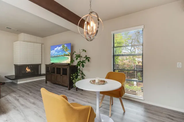 a kitchen with stainless steel appliances a dining table chairs and couches